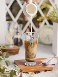 A glass of ice coffee milk on wooden tray on the table. brightmood concept