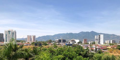 View of buildings in city against cloudy sky