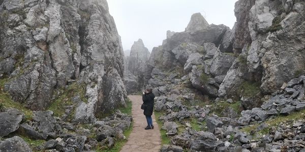 Rear view of man standing on rocks