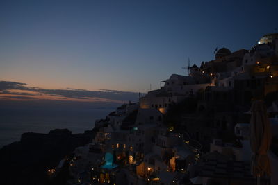 Town by sea against sky at sunset