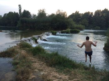 Rear view of boy standing at beach