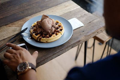 High angle view of hand holding ice cream in plate