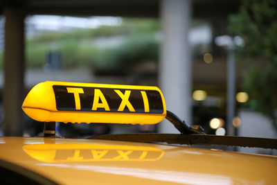 Close-up of yellow sign on car