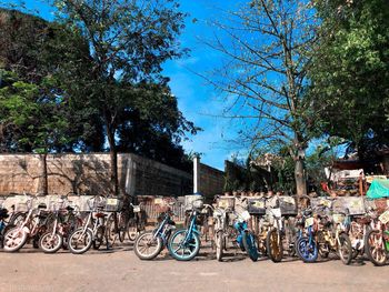 Bicycles parked on street in city against sky