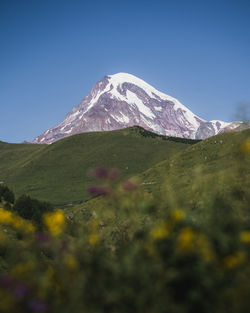 Scenic view of snowcapped mountains against clear blue sky