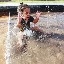 Boy splashing water in swimming pool