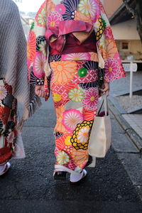 Rear view of woman standing on street