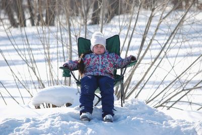 Full length of young man sitting on snow