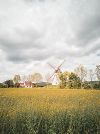 Scenic view of field against cloudy sky