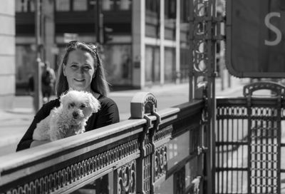 Portrait of woman with dog on railing
