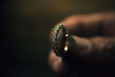 Close-up of cropped hand holding ring 