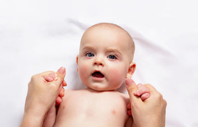 Caucasian funny child in white nappy lies on light background. top view. 