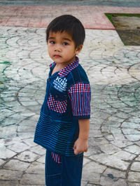 Cute boy standing on footpath