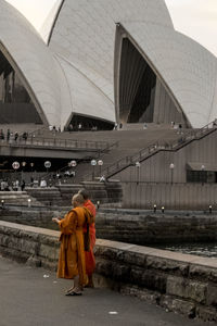 Rear view of people walking on bridge