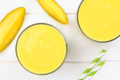 High angle view of yellow drink on table