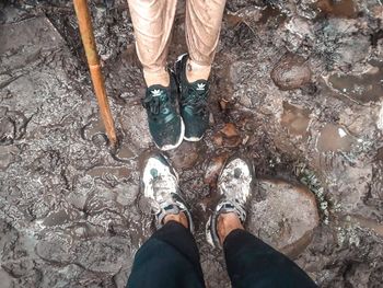 Low section of man standing on mud