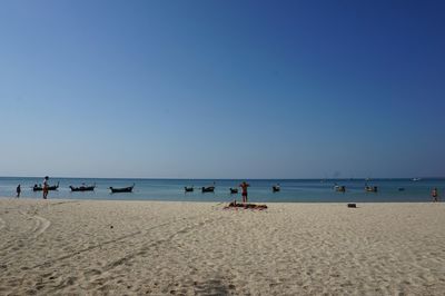 Scenic view of beach against clear blue sky