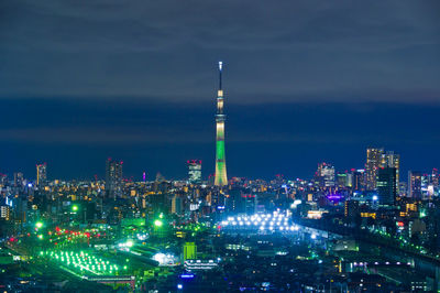 Illuminated buildings in city against sky at night