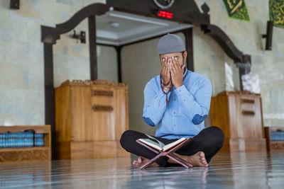 Full length of man praying at home