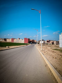 Empty road against blue sky