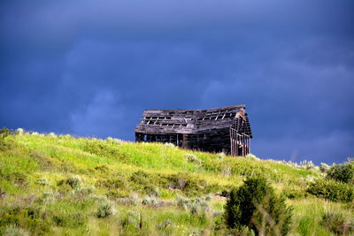 Abandoned built structure on field against sky