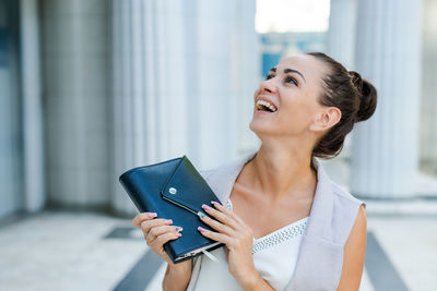 Successful businessman or entrepreneur smiling holding notepad while walking