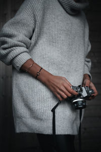 Midsection of woman holding camera