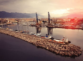 Cranes at commercial dock against sky