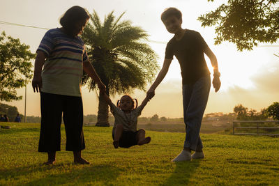 Rear view of people walking on field