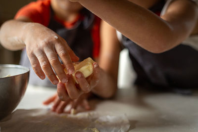 Close view of child's hands taking butter