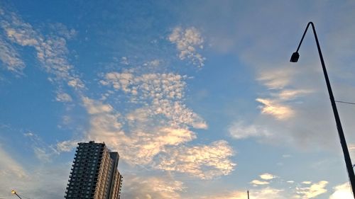 Low angle view of street light and buildings against sky