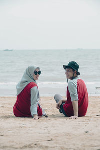 Rear view of woman sitting at beach