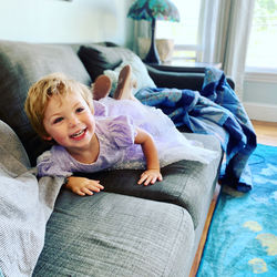 Portrait of girl lying on couch at home