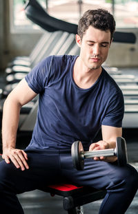 Lifestyle playful man having fun lifting dumbbell in gym exercise with work out program for healthy.