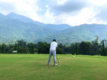 Full length of man standing on golf course against sky