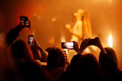 Group of people using smart phone at popular music concert