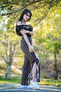 Portrait of smiling woman posing on road at park