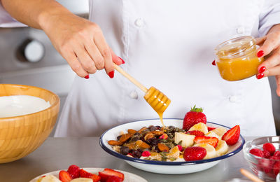 Midsection of chef preparing food in commercial kitchen