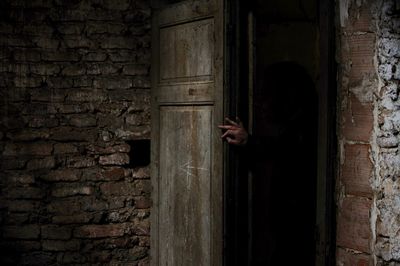 Man standing against wall in old building