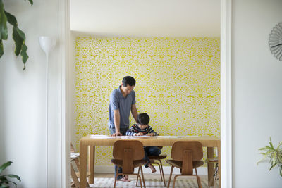 Father helping son with homework at home