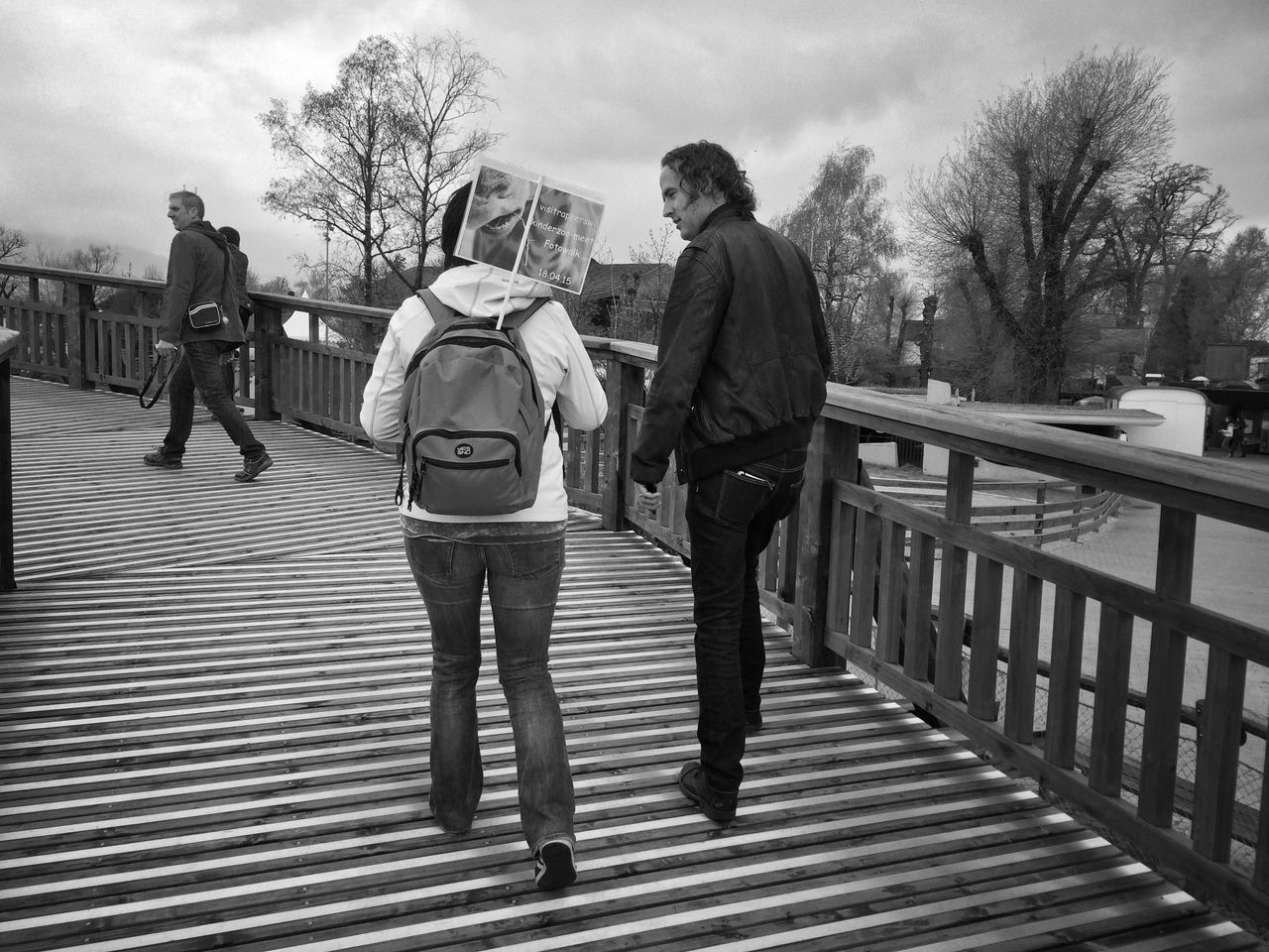 full length, lifestyles, railing, rear view, walking, built structure, tree, leisure activity, building exterior, architecture, sky, men, the way forward, casual clothing, person, togetherness, city