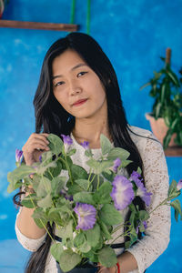 Portrait of a beautiful young woman holding flower