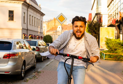 Portrait of young man riding push scooter