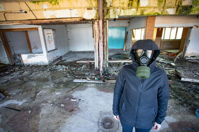 Full length portrait of man standing in abandoned building