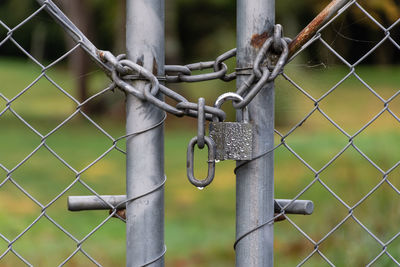 Close-up of chain hanging on chainlink fence
