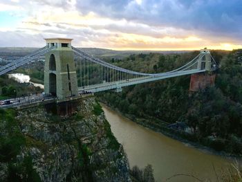 Bridge over river against cloudy sky
