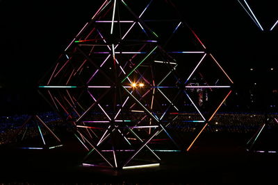 Low angle view of illuminated lights against sky at night