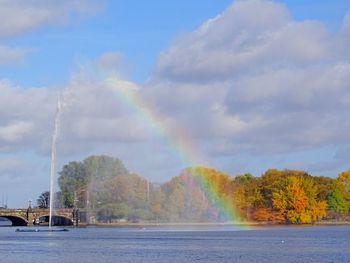 Panoramic view of rainbow over trees against sky