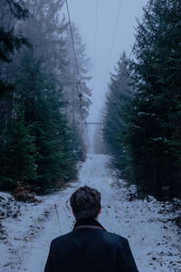 Rear view of man on snow covered land