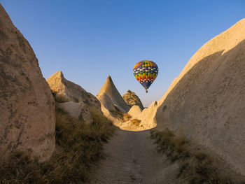 Hot air balloon flying over rock formations in cappadocia